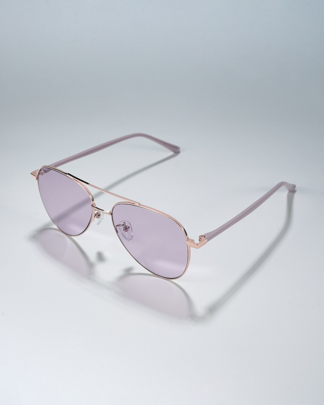 Studio product photograph of polarized aviator sunglasses with gold frames