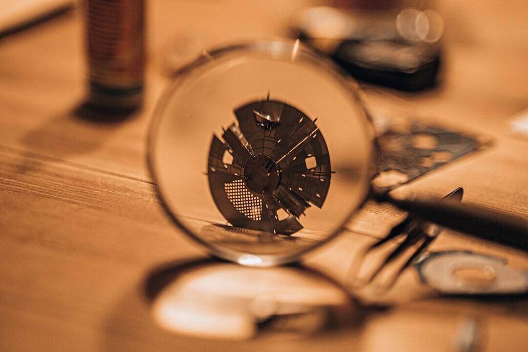 Watchmaker's hands assembling a movement using a loupe and fine tools